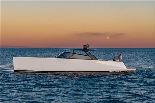 2025 VanDutch 75 yacht cruising at sunset with people on deck.