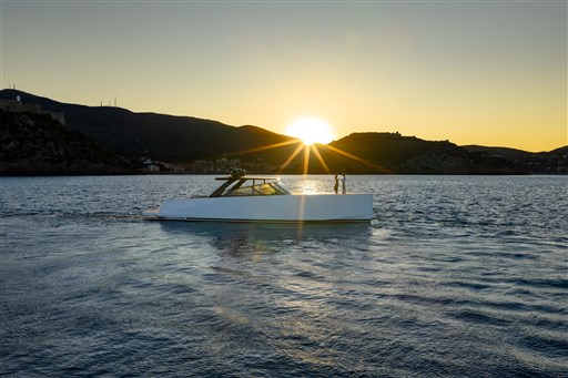 VanDutch 75 yacht cruising at sunset, 2025 model, serene waters, scenic mountain backdrop.