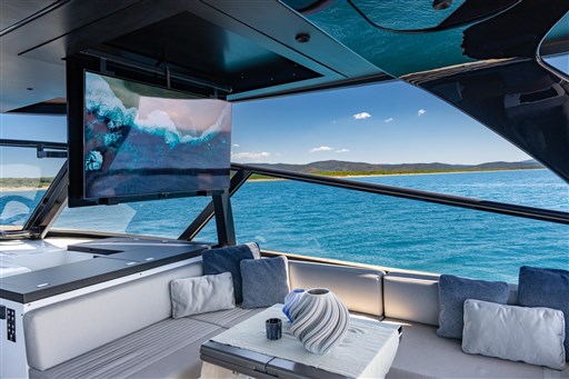 Luxurious VanDutch 75 yacht interior with ocean view, featuring a TV and elegant seating area.