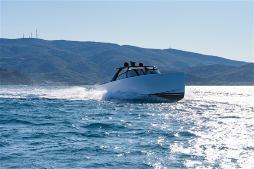 2025 VanDutch 75 yacht cruising on open water with mountainous backdrop.