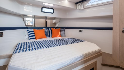 Luxurious cabin interior of 2024 Apreamare GOZZO 38, featuring stylish bedding and vibrant cushions.