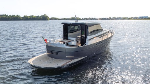 2024 Apreamare GOZZO 38 CABIN yacht on calm water, rear view.