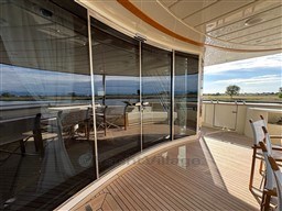 Luxurious 2008 Riva 115 Athena yacht deck with glass doors and elegant seating.