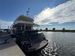 Luxury 2008 Riva 115 Athena yacht docked under a bright sunlit sky.