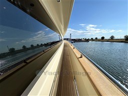 Side view of 2008 Riva 115 Athena yacht on a sunny day by the water.