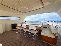 Luxurious 2008 Riva 115 Athena yacht deck with seating and scenic waterfront view.