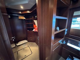 Luxurious wooden interior of 2008 Riva 115 Athena yacht with shelves and closet space.