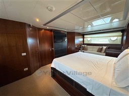 Luxurious bedroom interior on 2008 Riva 115 Athena yacht with wood paneling and elegant furnishings.