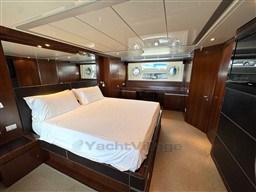 Luxurious bedroom interior of 2008 Riva 115 Athena yacht with elegant wood finishes.