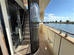 Luxurious 2008 Riva 115 Athena yacht deck with glass doors and scenic water view.