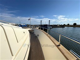 2008 Riva 115 Athena yacht deck with railing, docked by calm waters under a clear sky.