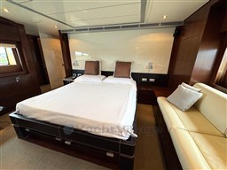 Luxurious bedroom interior on 2008 Riva 115 Athena yacht, featuring elegant wood finishes.