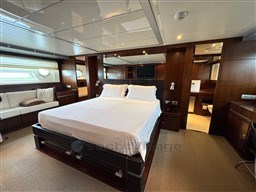 Luxurious bedroom interior of 2008 Riva 115 Athena yacht with elegant wood finishes.
