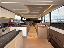 Luxurious interior of a 2019 Prestige 590 yacht with modern kitchen and seating area.