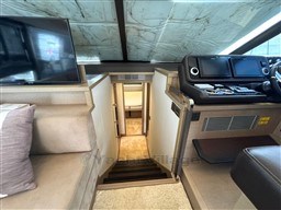 Interior of 2019 Prestige 590 yacht with helm, stairs, and seating area.