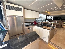 Luxurious kitchen interior of 2019 Prestige 590 yacht with modern appliances and sleek design.
