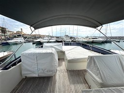 Prestige 590 yacht deck, 2019 model, docked in marina with covered seating and canopy.