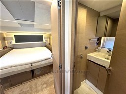 Luxurious interior of 2019 Prestige 590 yacht featuring bedroom and bathroom.