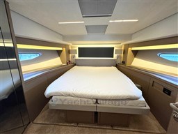 Luxurious bedroom interior of a 2019 Prestige 590 yacht with modern design and ambient lighting.