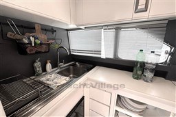 Compact kitchen area in a 1989 Mochi Craft MOCHI 56 yacht with sink and storage.