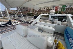 Flybridge of 1989 Mochi Craft MOCHI 56 yacht with white seating and city view.