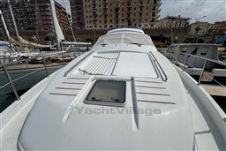 1989 Mochi Craft MOCHI 56 yacht docked in a marina, surrounded by buildings.