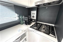 Compact kitchen in 1989 Mochi Craft MOCHI 56 yacht with stove, coffee maker, and storage.