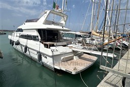 1989 Mochi Craft MOCHI 56 yacht docked in a marina, featuring sleek design and spacious deck.