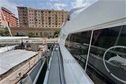 1989 Mochi Craft MOCHI 56 yacht docked in a marina, with city buildings in the background.