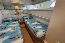 Twin beds with airplane-themed bedding in 1989 Mochi Craft MOCHI 56 yacht cabin.