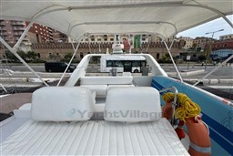 1989 Mochi Craft MOCHI 56 yacht with white seating, docked in urban marina setting.