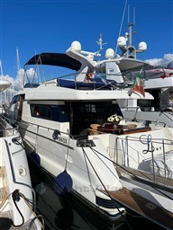 Sanlorenzo 62 yacht, 1996 model, docked at marina under clear blue sky.