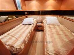 Twin cabin with beige bedding in a 1996 Sanlorenzo 62 yacht.