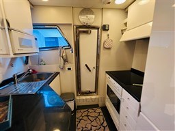 Compact kitchen interior of a 1996 Sanlorenzo 62 yacht with modern appliances.