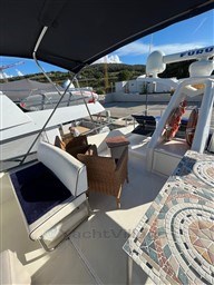 1996 Sanlorenzo 62 yacht deck with seating and mosaic table under canopy.