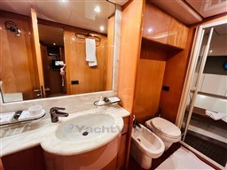 Luxurious bathroom in 1996 Sanlorenzo 62 yacht with modern fixtures and wooden cabinetry.