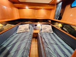 Twin cabin with striped bedding in 1996 Sanlorenzo 62 yacht.