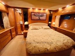 Luxurious bedroom interior of a 1996 Sanlorenzo 62 yacht with elegant wood finishes.