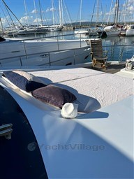 Sanlorenzo 62 yacht (1996) with sunbathing area, docked in marina with sailboats.