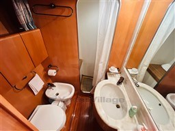 Bathroom interior of 1996 Sanlorenzo 62 yacht with wood paneling and modern fixtures.
