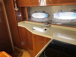 2005 Jeanneau Prestige 34 S yacht kitchen with wooden cabinetry and modern appliances.