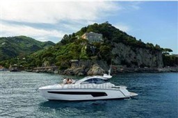 2025 Azimut Atlantis 45 yacht cruising near a scenic coastal landscape.