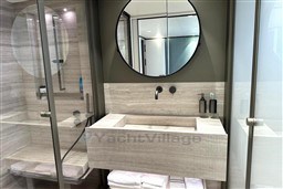 Modern bathroom on 2024 Sanlorenzo SL120 A yacht with sleek design and round mirror.