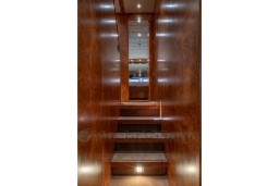 Interior staircase of 1999 Mangusta 105 Sport yacht with wooden paneling.