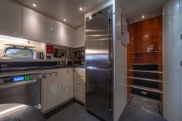 Modern kitchen interior on 1999 Mangusta 105 Sport yacht, featuring sleek cabinetry and stainless steel appliances.