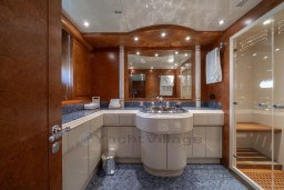 Luxurious bathroom interior of 1999 Mangusta 105 Sport yacht with elegant fixtures and wood accents.