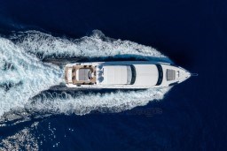 Overhead view of 1999 Mangusta 105 Sport yacht cruising on open water.