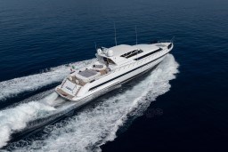 Mangusta 105 Sport 1999 yacht cruising on open sea, aerial view.