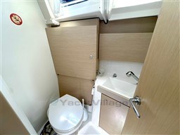 Bathroom interior of 2021 Beneteau Oceanis 38.1 yacht, featuring toilet and sink.