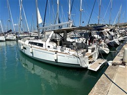 2021 Beneteau Oceanis 38.1 yacht docked in a marina under clear blue skies.